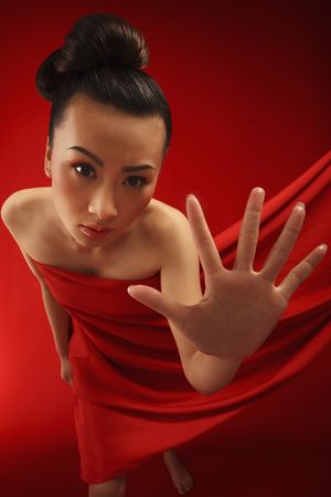 Woman wrapped in red cloth, showing her palmの写真素材