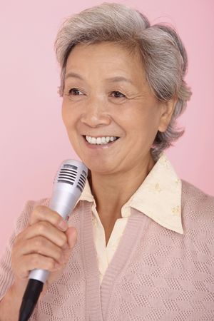 Senior woman singing into microphoneの写真素材