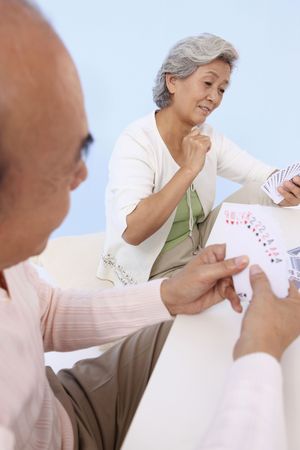 Senior man and senior woman playing cardsの写真素材
