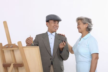 Senior woman complimenting senior man's art workの写真素材