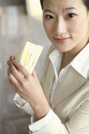 Businesswoman enjoying sandwichの写真素材
