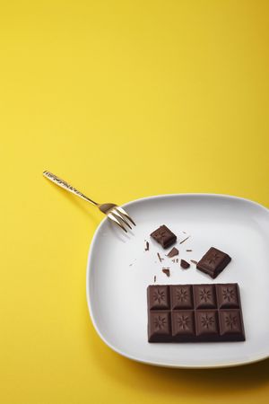 Chocolate bar and fork on a plateの写真素材