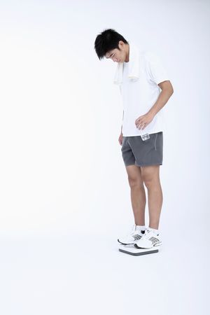 Man standing on weight scaleの写真素材