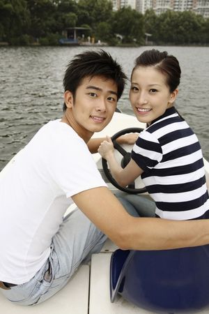 Man and woman traveling on the boat, smilingの写真素材