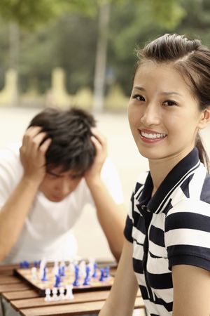 Woman smiling, man with hands on head in the backgroundの写真素材