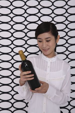 Businesswoman holding a bottle of wineの写真素材