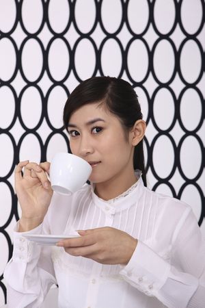 Businesswoman enjoying tea at her deskの写真素材