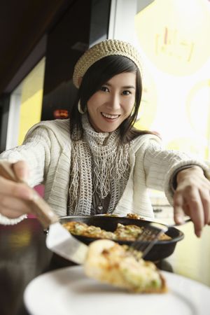 Woman serving pizza on a plateの写真素材