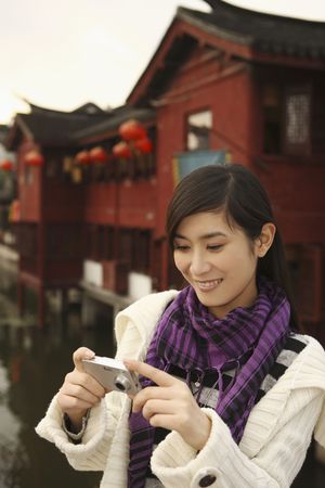 Woman looking at pictures taken with digital cameraの写真素材