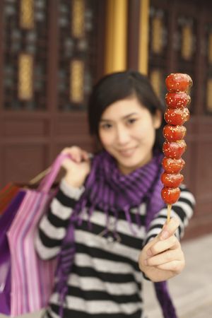 Woman holding paper bags and sugar-coated strawberriesの写真素材