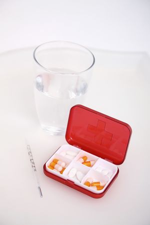 Glass of water, medication and thermometerの写真素材
