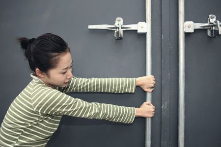 Woman trying to open doorの写真素材