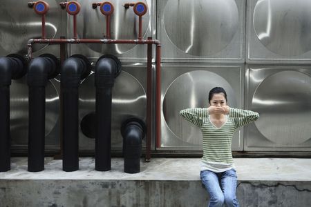 Woman with her hands covering mouthの写真素材