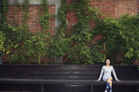 Woman sitting on wooden benchの写真素材