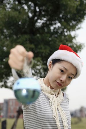 Woman with Christmas hat holding Christmas ornamentの写真素材