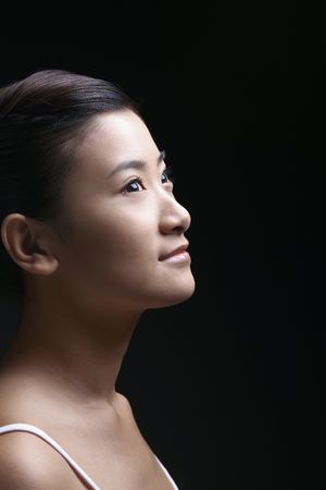 Beautiful young woman looking upの写真素材