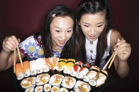Young women looking at the variant of sushiの写真素材