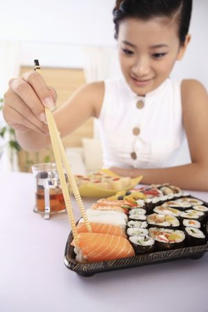Young woman enjoying japanese cuisineの写真素材