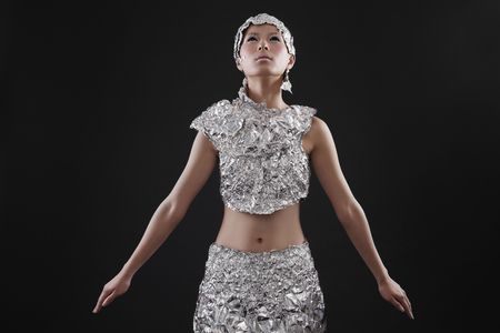 Woman wearing foil accessories looking upwardsの写真素材