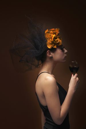 Woman with net and flower decorating her hair holding wine glassの写真素材
