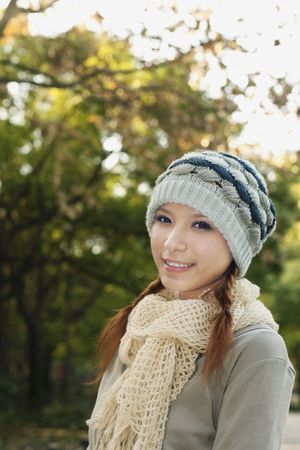 Woman wearing scarf and knit hat smilingの写真素材