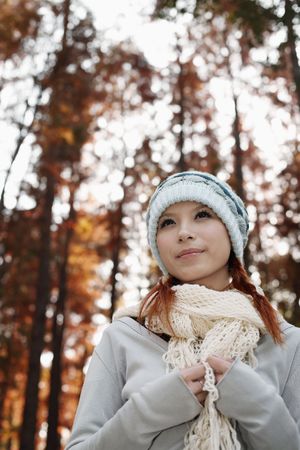 Woman wearing scarf and knit hat looking awayの写真素材