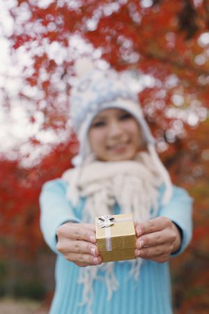 Woman smiling while holding gift, focus on giftの写真素材