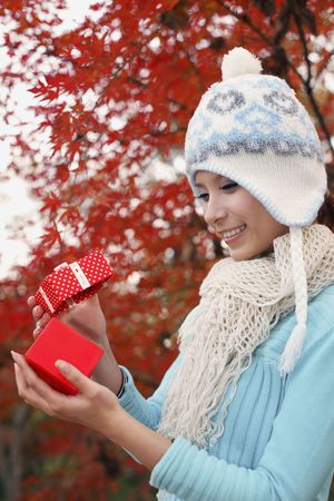 Woman wearing knit hat opening giftの写真素材