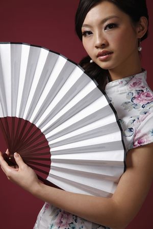 Woman in cheongsam holding fanの写真素材