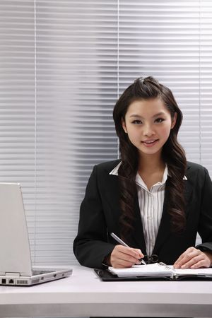 Woman smiling while writingの写真素材