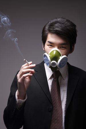 Man with gas mask smoking cigaretteの写真素材