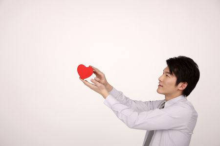 Man showing a red heart shaped boxの写真素材