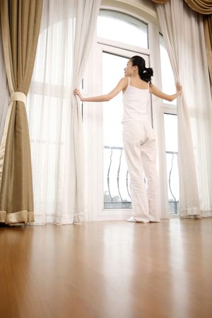 Young woman standing in doorway to balconyの写真素材
