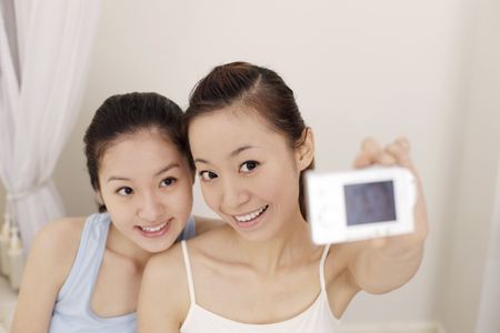 Young women taking picture togetherの写真素材
