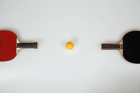 Table tennis bats and table tennis ball in the middleの写真素材