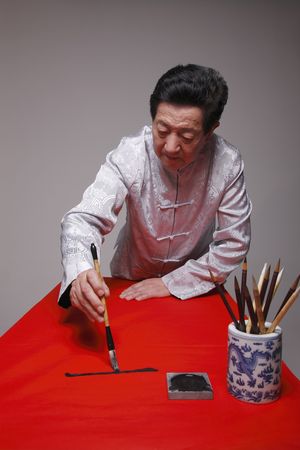 Senior man writing calligraphyの写真素材