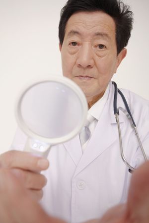Doctor holding magnifying glassの写真素材