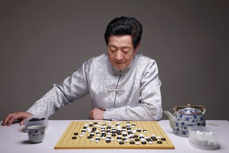 Senior man playing japanese board gameの写真素材