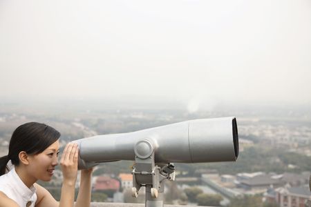 Woman looking through telescopeの写真素材