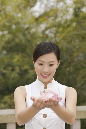 Woman with flower petals on cupped handsの写真素材