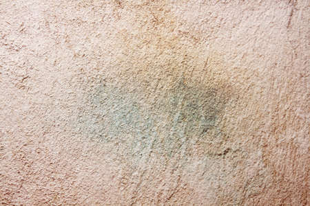 Realistic old beige plaster wall background degraded, damaged with stainsの写真素材