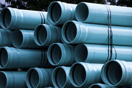Sewer pipes waiting to be placed into the ditch at construction site.の写真素材