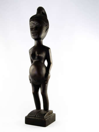 Hand carved fertility goddess on a white background.の写真素材