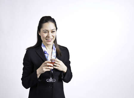 Young business woman holding a glass of wine in her hand, She is of filipino ethnicity.の写真素材