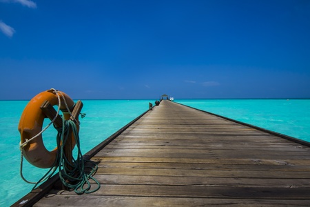 life belt on a wooden jetty leading to the horizonの写真素材