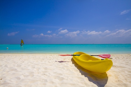 yellow kayak at the beach and windsurfer at the seaの写真素材