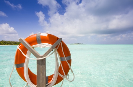 life belt at the sea with island blue sky and cloudsの写真素材