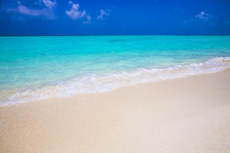 little wave at a tropical beach in summer, with blue sky and turquoise seaの写真素材
