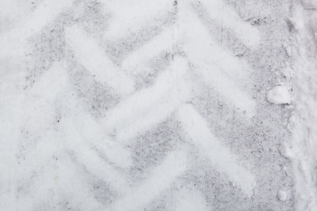 background of truck tracks on a snowy and icy grey surfaceの写真素材