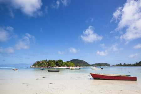 small red fishing boat at the beach before an tropical islandの写真素材